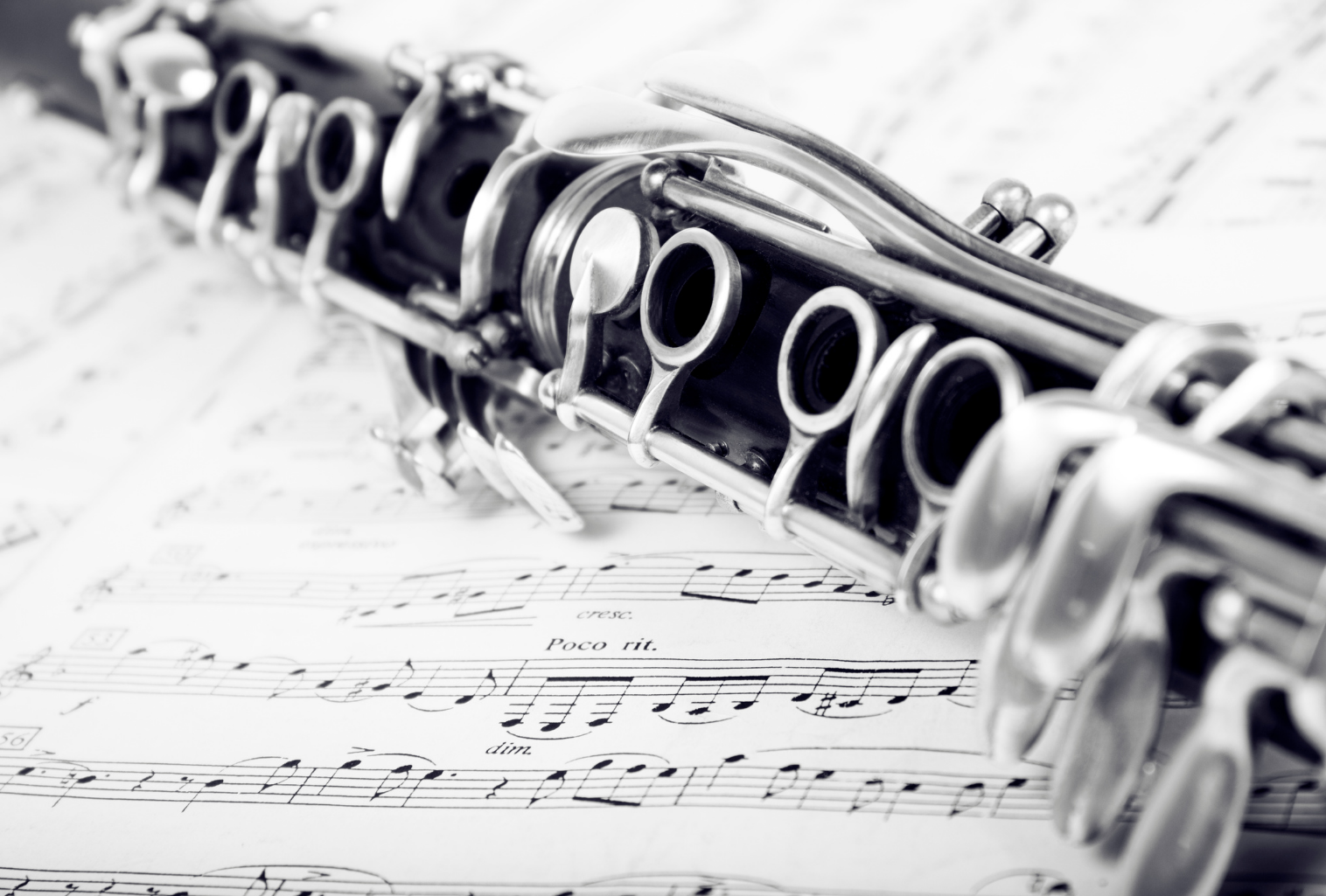 A picture of a clarinet on top of a music score sheet.