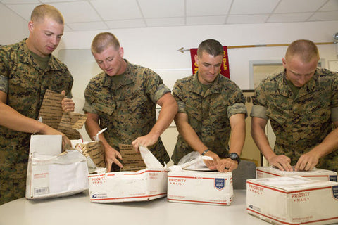Military troops opening care packages