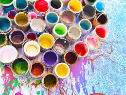 multiple paint cans with all different colors on top of a paint splattered canvas