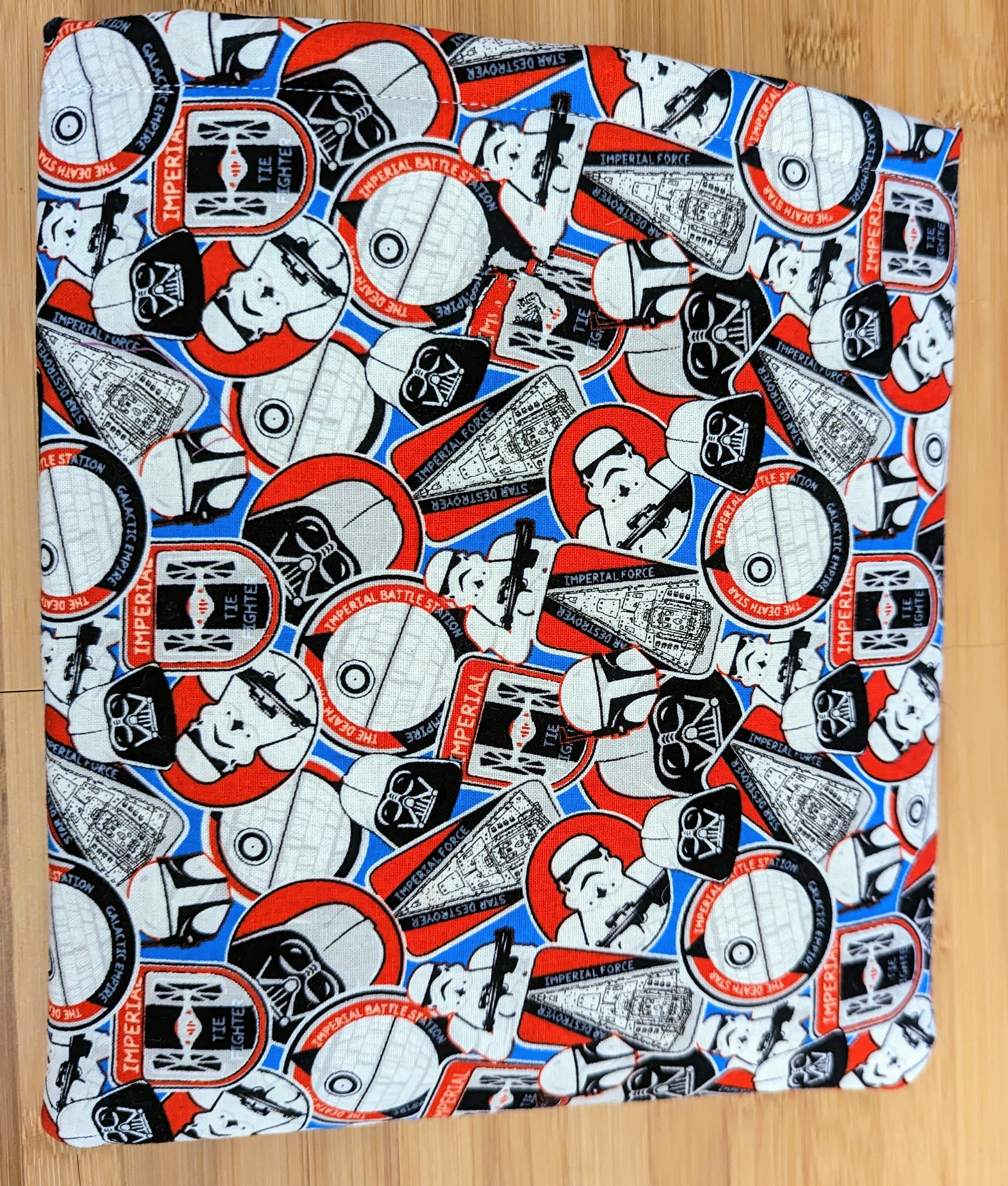 A rectangular sleeve the size of a book with a red and blue Star Wars pattern.