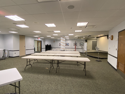 Combined Meeting Room A/B with several tables, a rolling whiteboard, and a projector screen