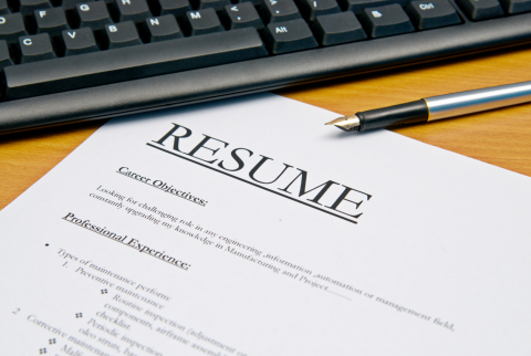 Graphic with a resume and computer keyboard.