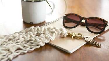 A macrame keychain and black sunglasses on a notepad.