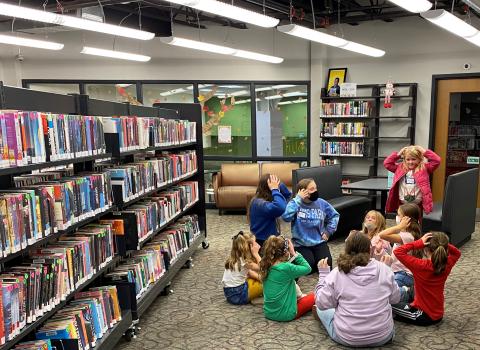 Group of teens and kids playing a game in a circle
