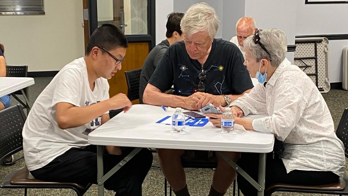teen helping senior citizens with their cell phone